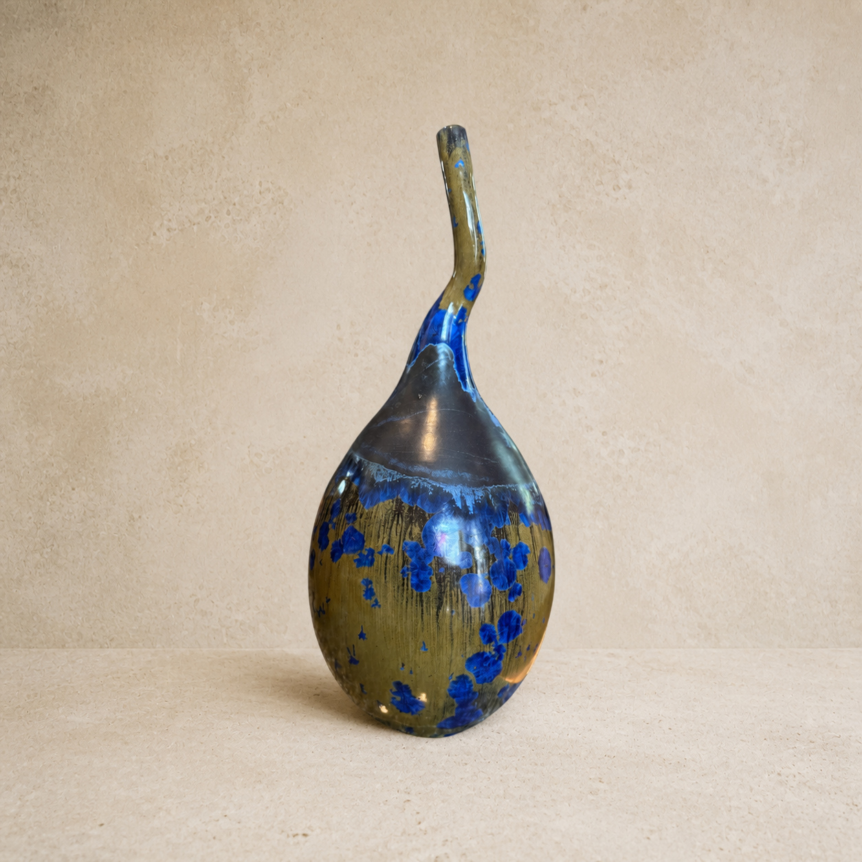 Blue and gold sculptural ceramic bottle with a curved neck by Mark Barta