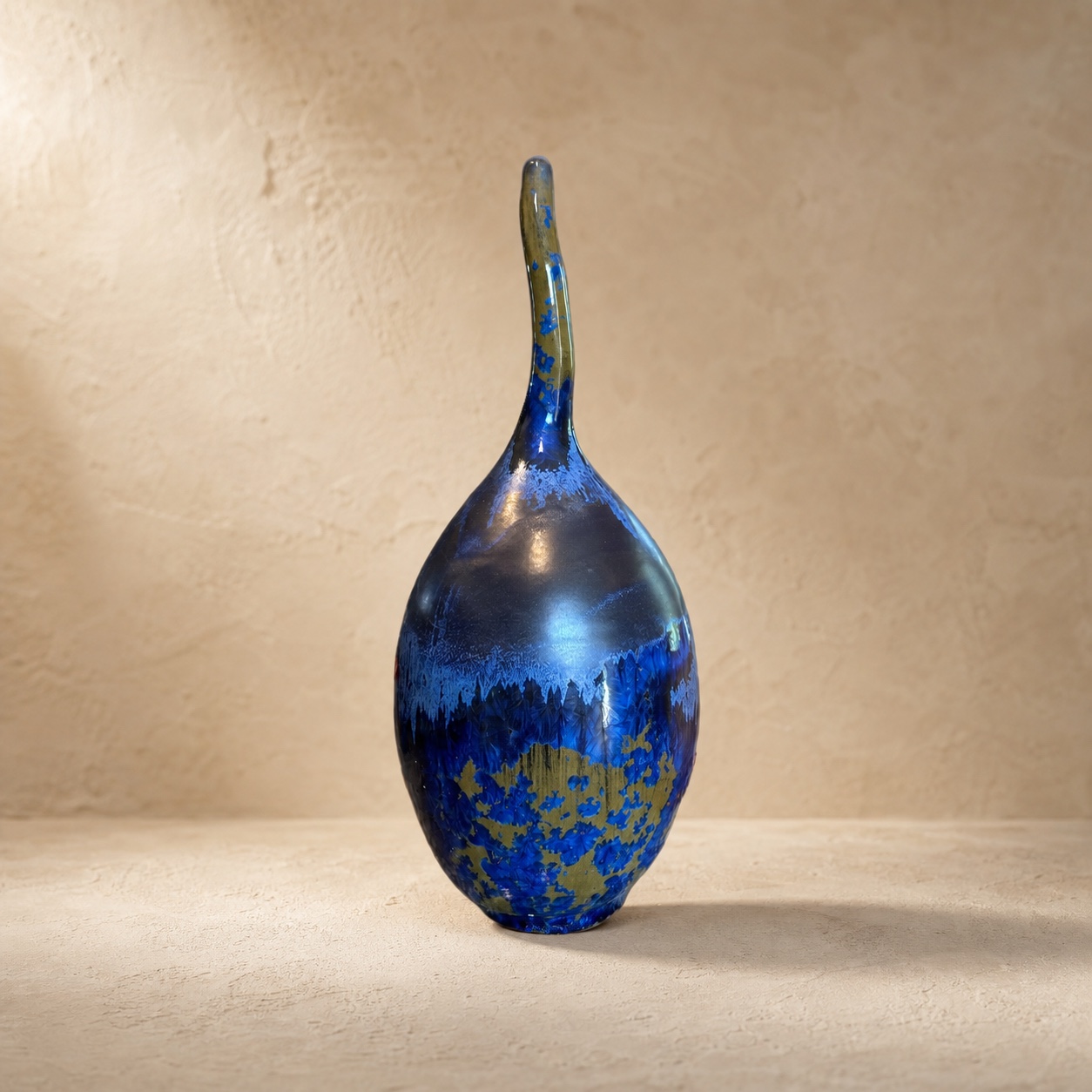Tall blue sculptural bottle with a curved neck by Mark Barta