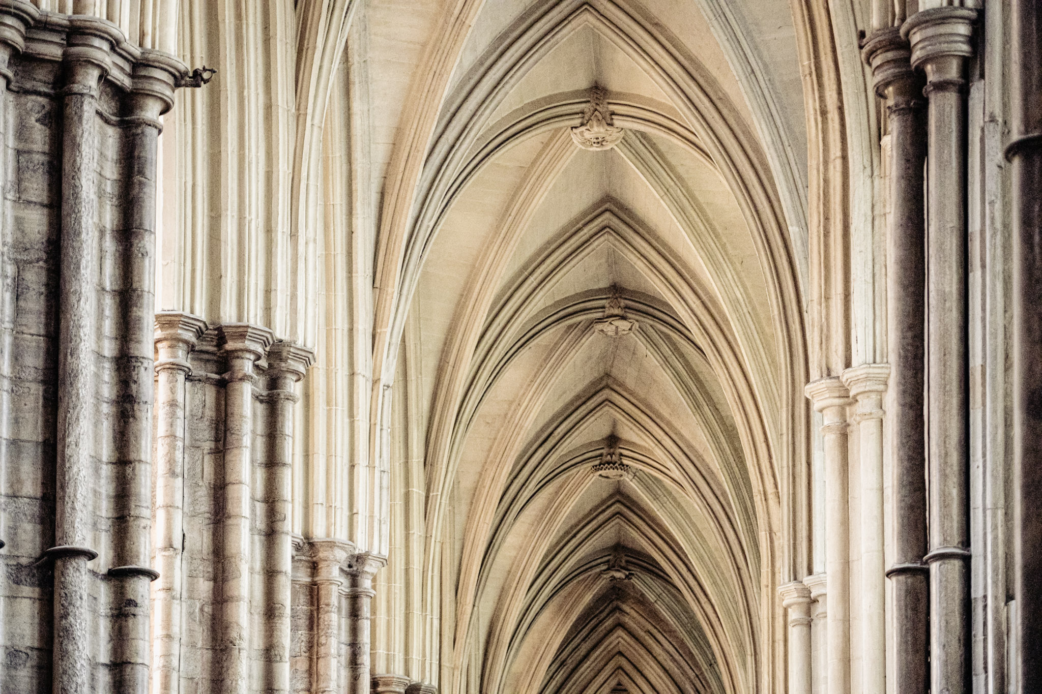 Repeating pointed arches and pale ribbed vaults inside Westminster Abbey