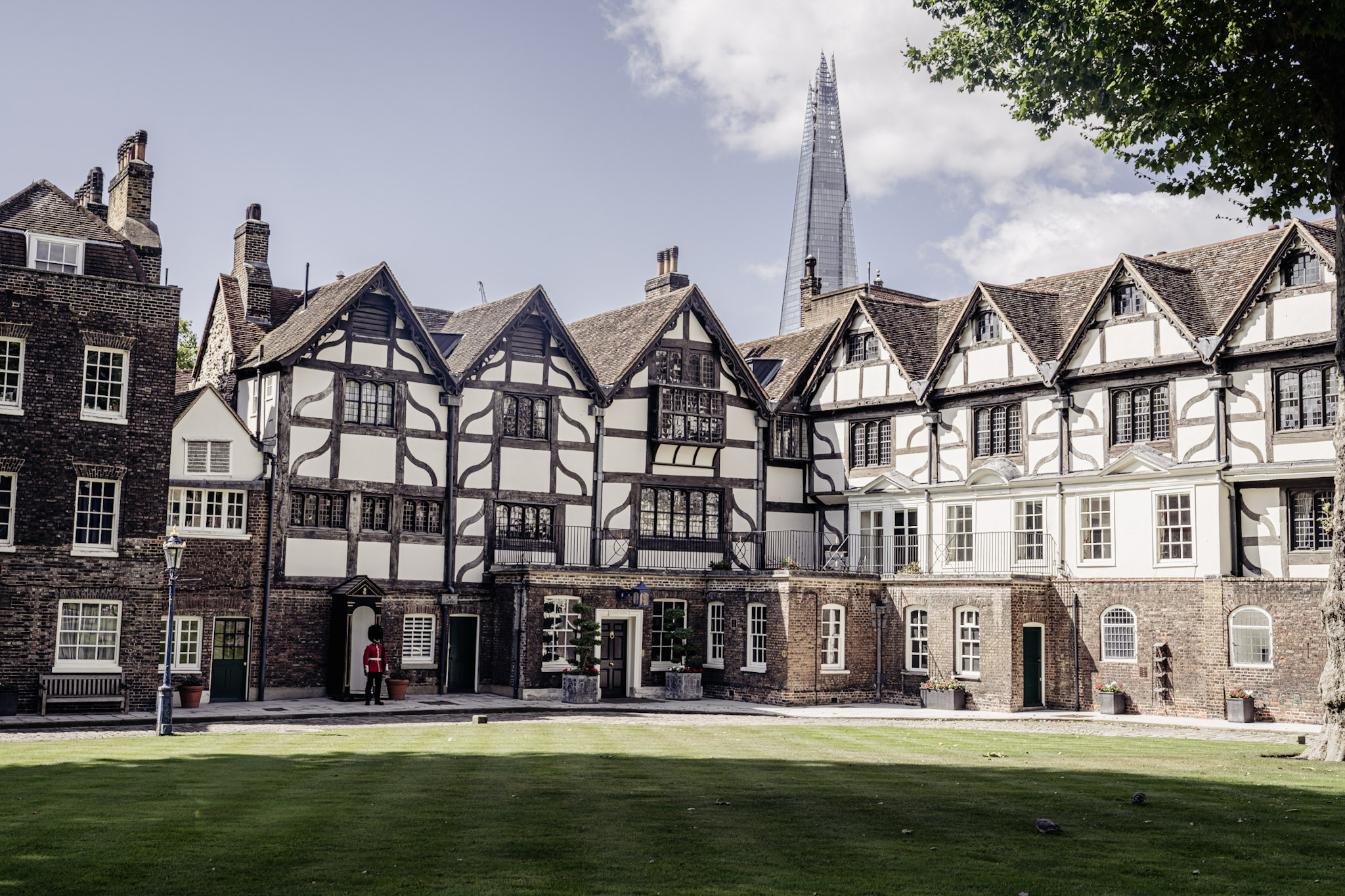 Timber-framed King's House and neighbouring residences on Tower Green with The Shard rising behind them