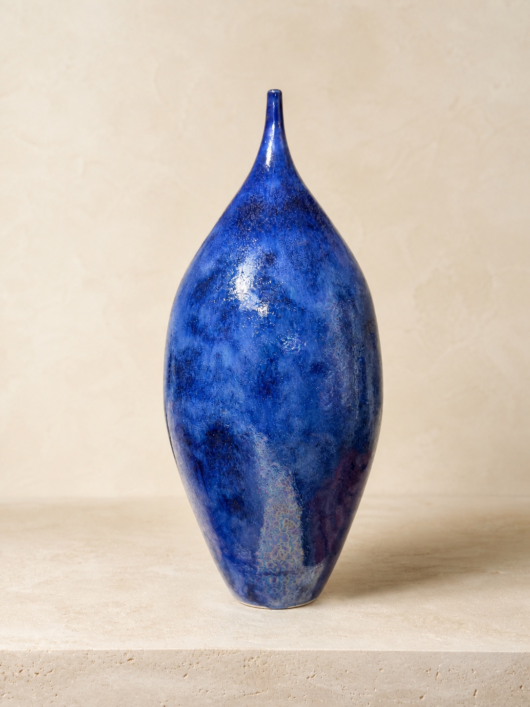 Tall cobalt blue ceramic bottle with a narrow pointed neck by Mark Barta