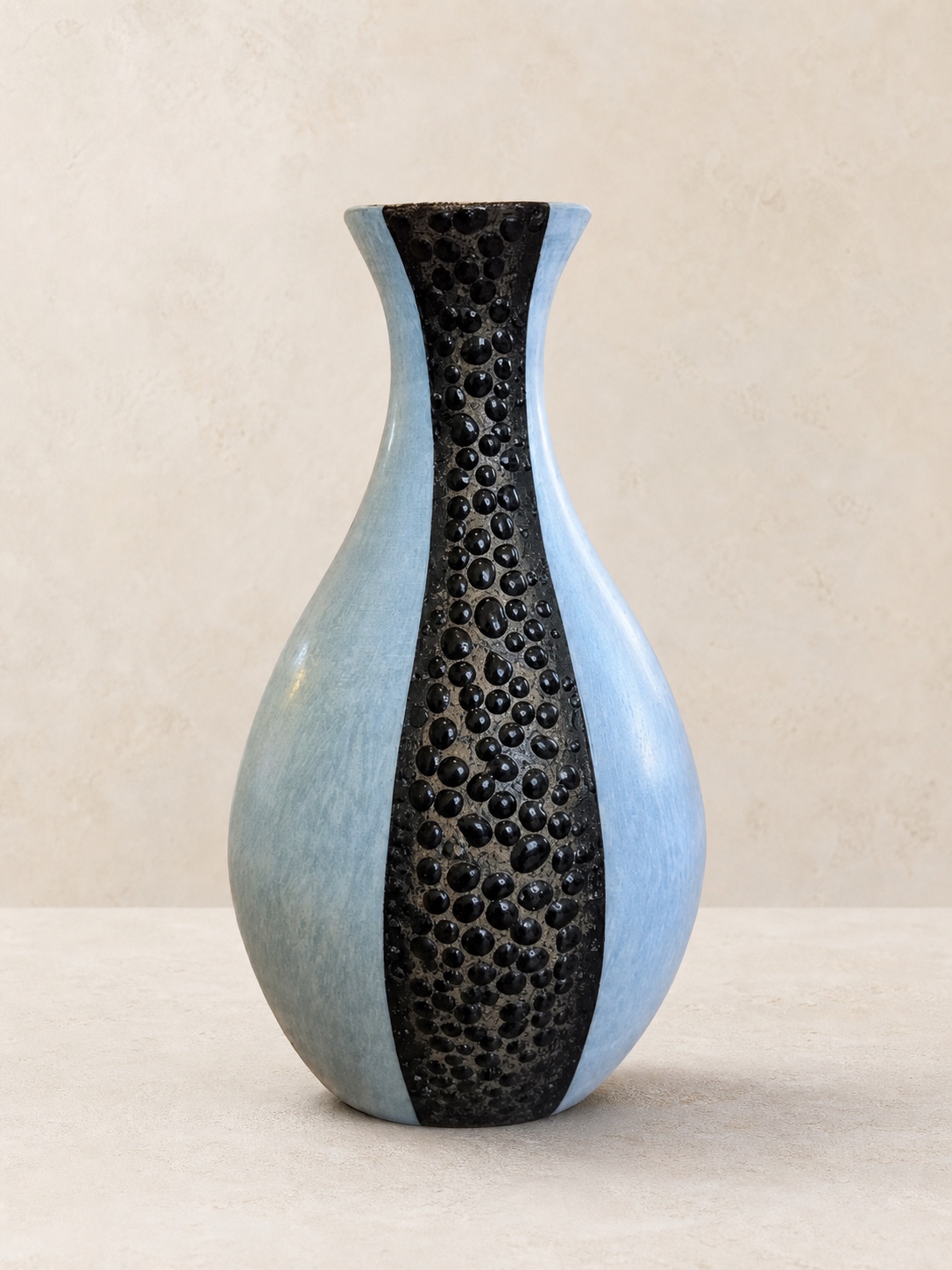 Pale blue sculptural ceramic bottle with a raised black pebble-textured strip by Mark Barta