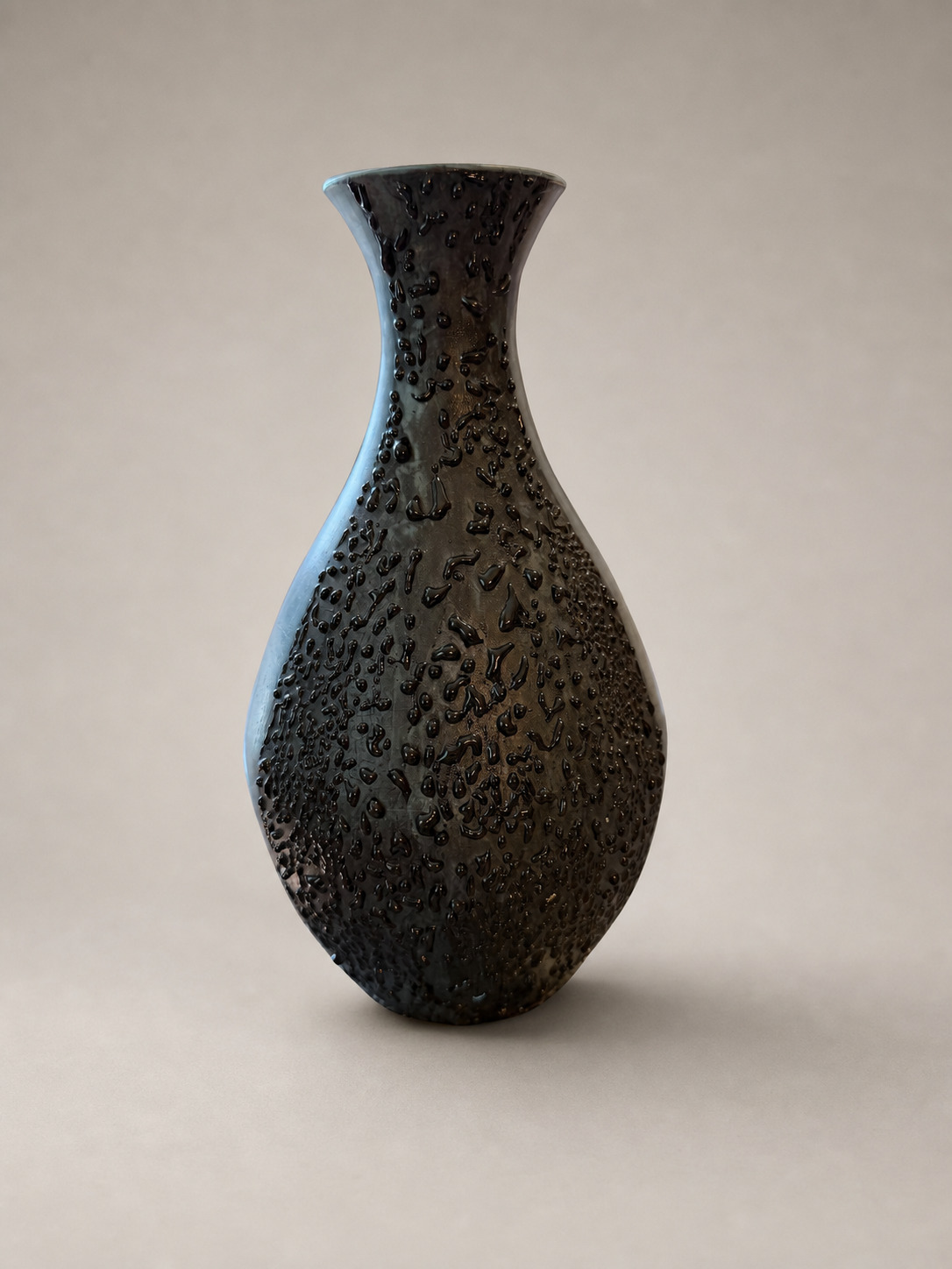 Front angle of a terra sigillata vase covered by a glossy raised black textured passage
