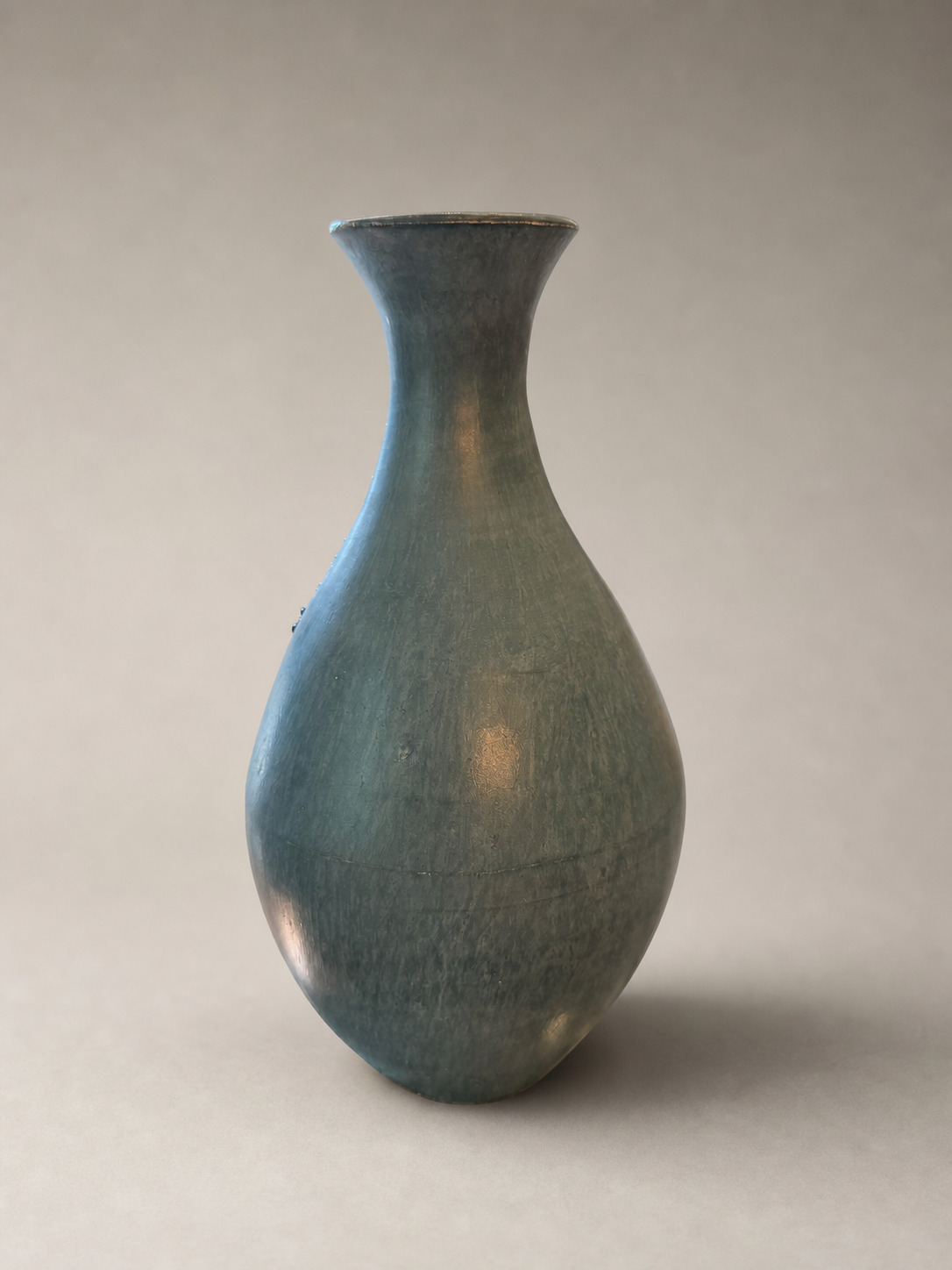 Plain satin blue-green side of a long-necked terra sigillata ceramic vase